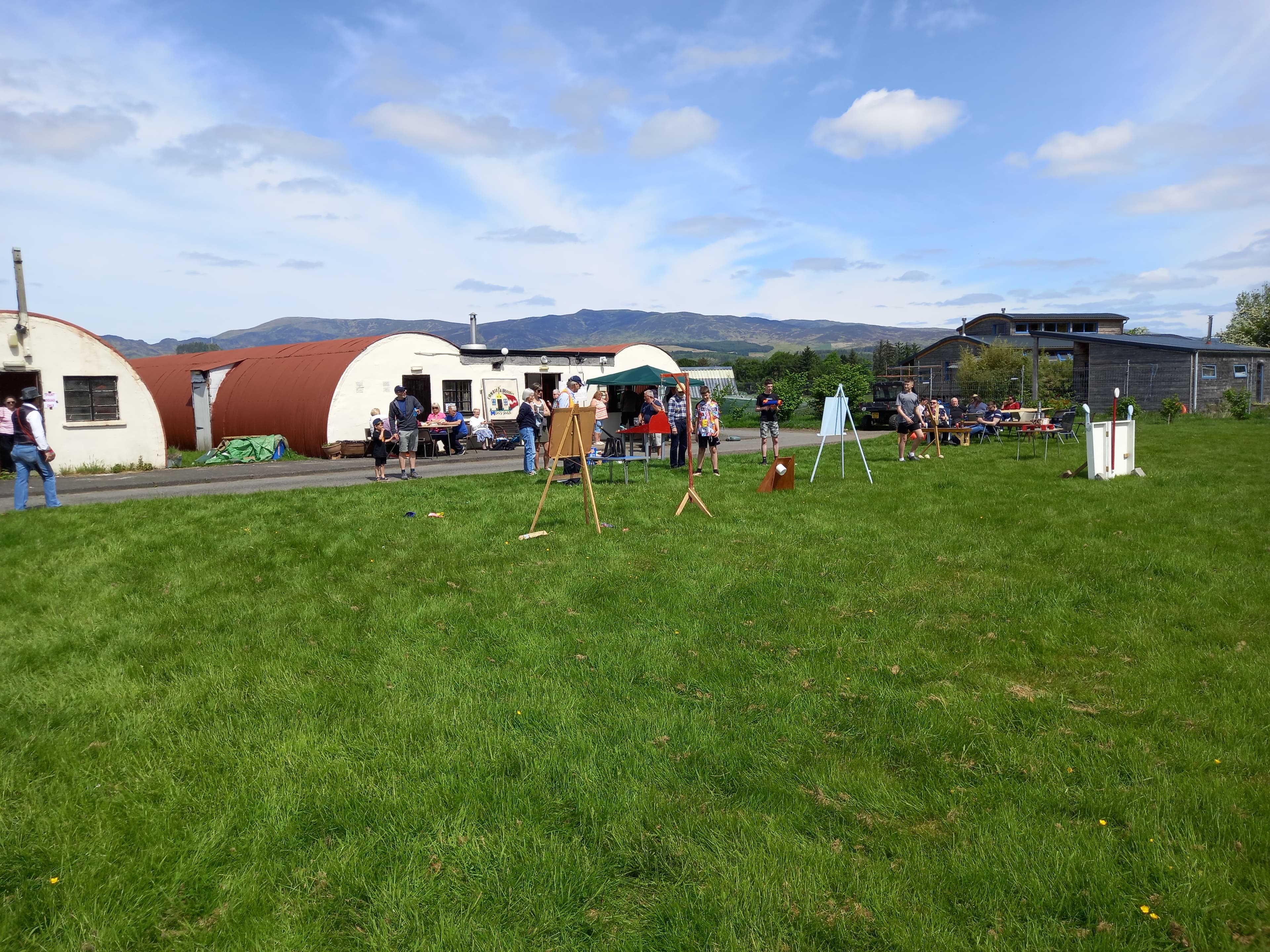 Community event on the grounds of Cultybraggan Camp with Nissen huts and Perthshire hills in the background