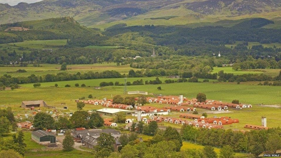 Aerial view of Cultybraggan Camp showing fields, Nissen huts, and Perthshire hills